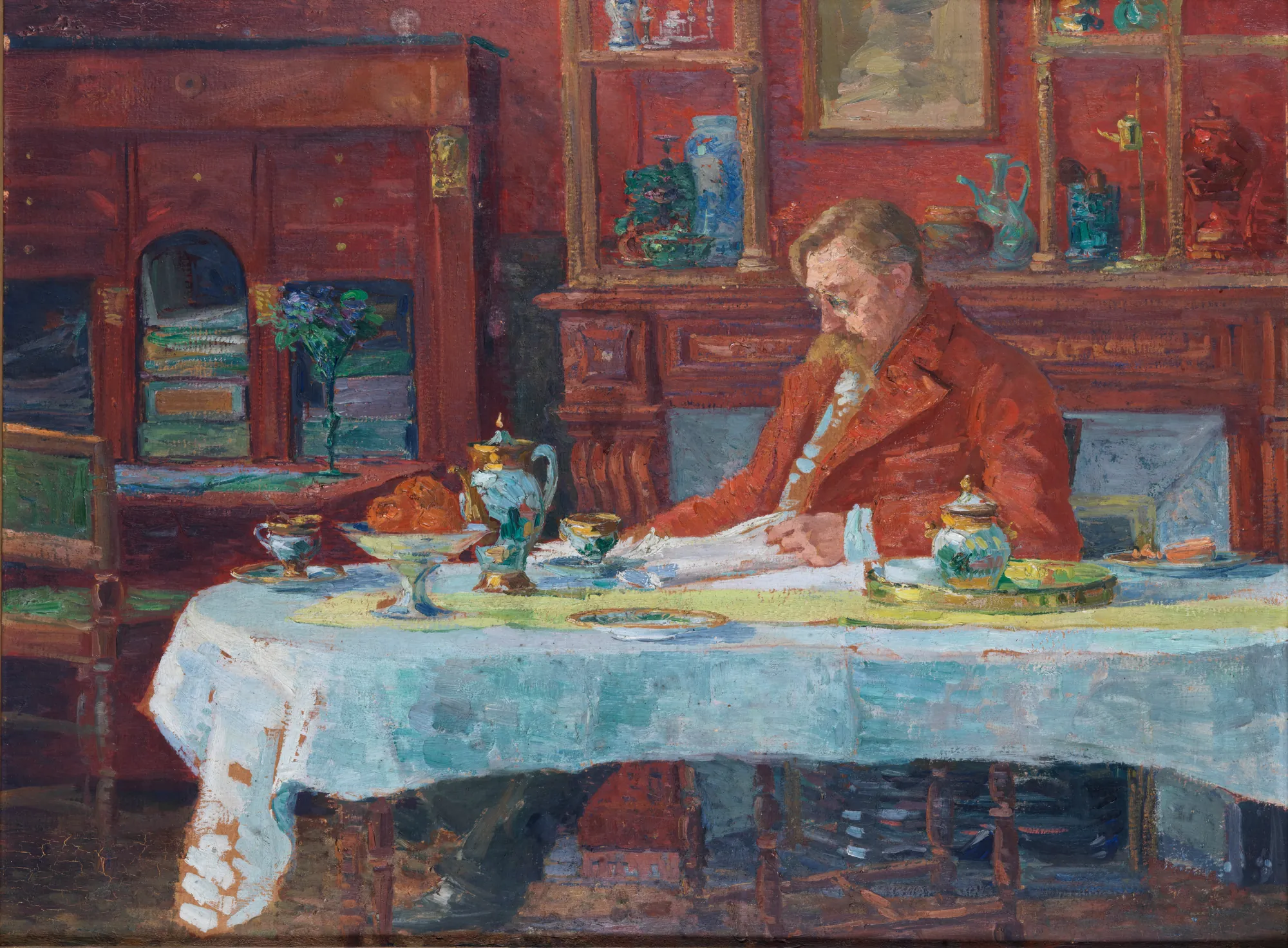 Verhaeren at the Table Verhaeren at the Table by Marthe Massin. A bearded man in a red jacket sits at a table covered with a white cloth, surrounded by books and ceramic vessels in a warmly lit room.