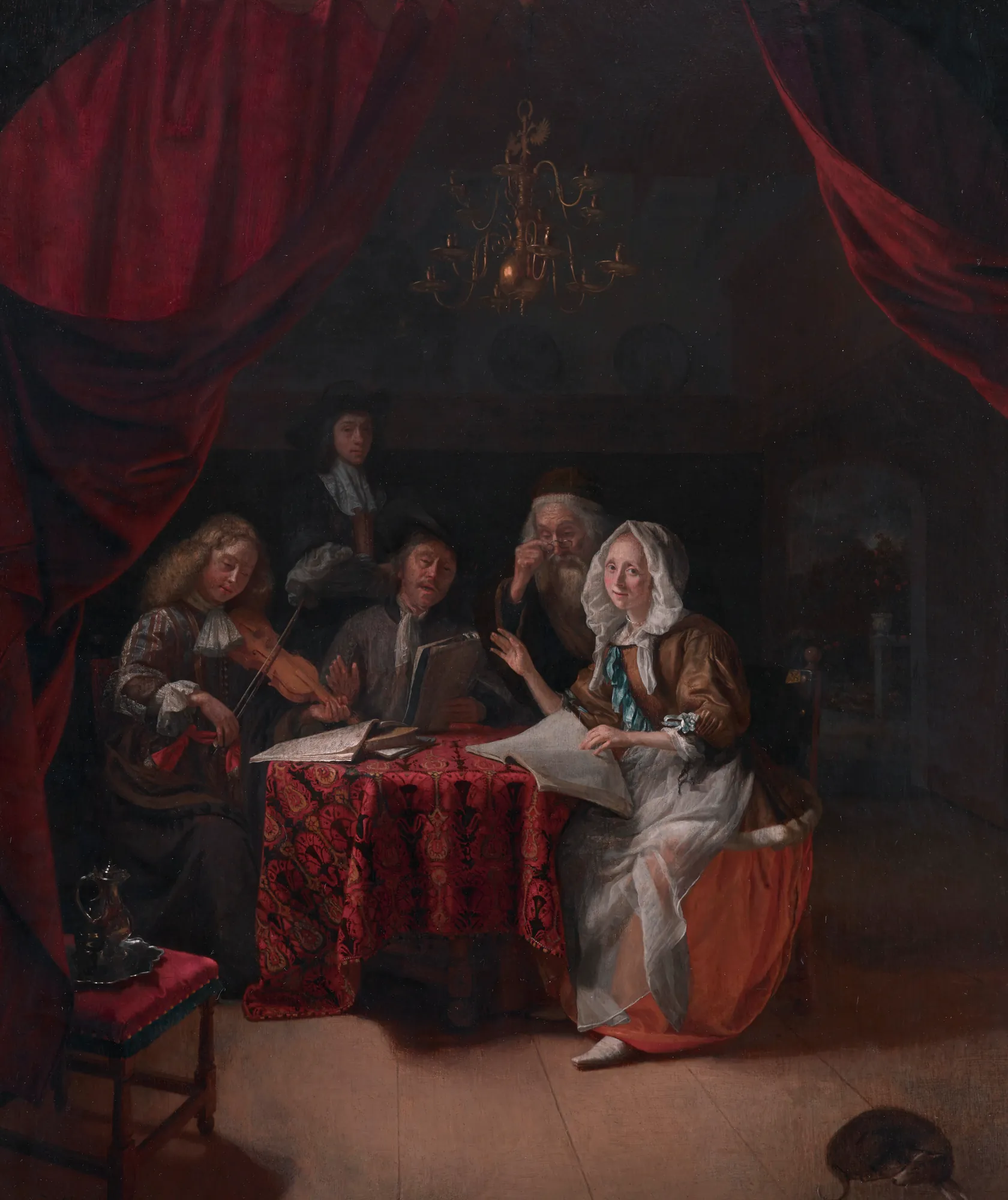 A Family Concert A Family Concert by Godfried Schalcken. A group of figures gathered around a candlelit table draped in red, engaged in a musical performance inside a dark interior.