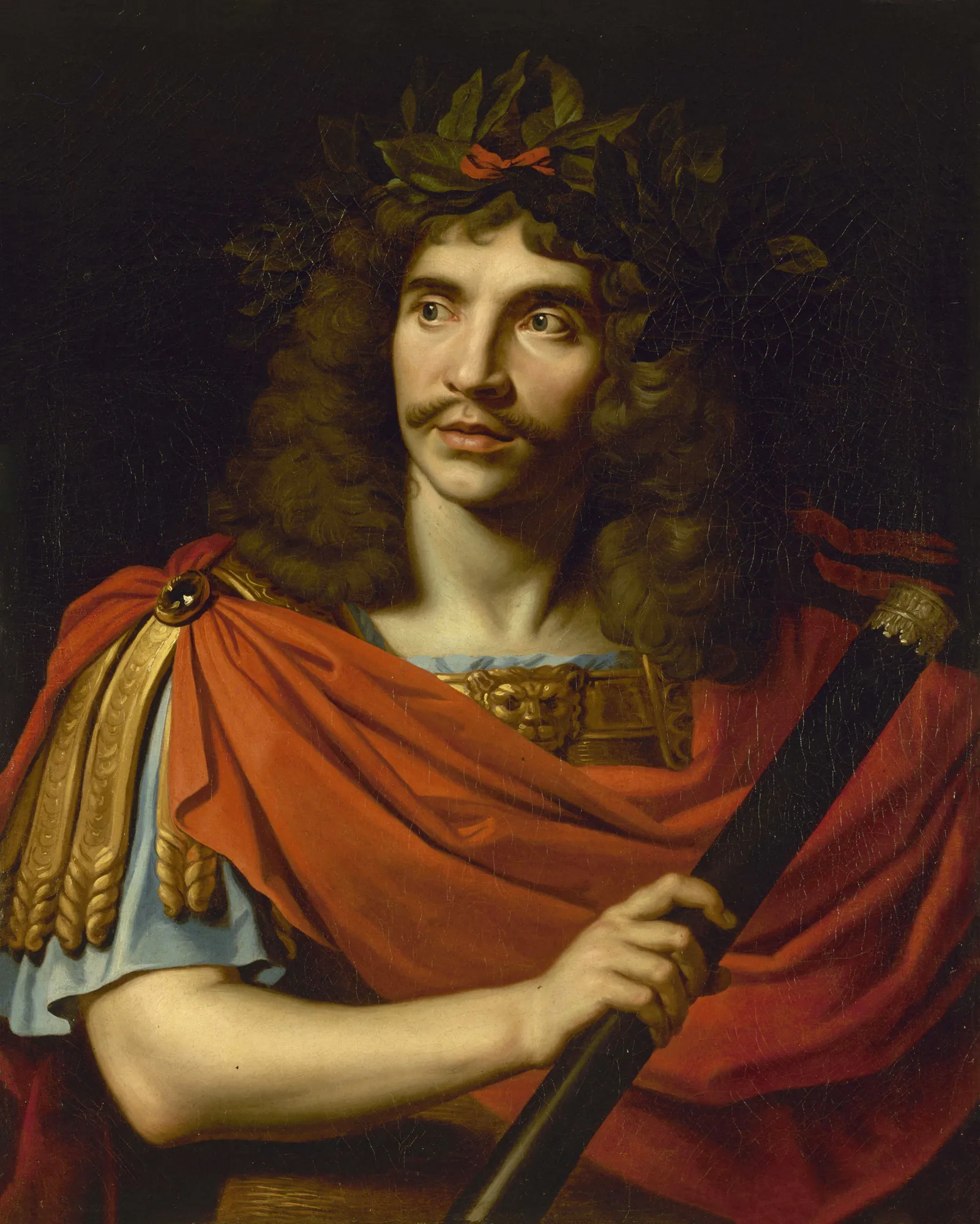Portrait of Molière Portrait of Molière by Nicolas Mignard. A portrait of a man with long dark hair wearing a laurel wreath and a bright red cloak, holding a black baton against a dark background.