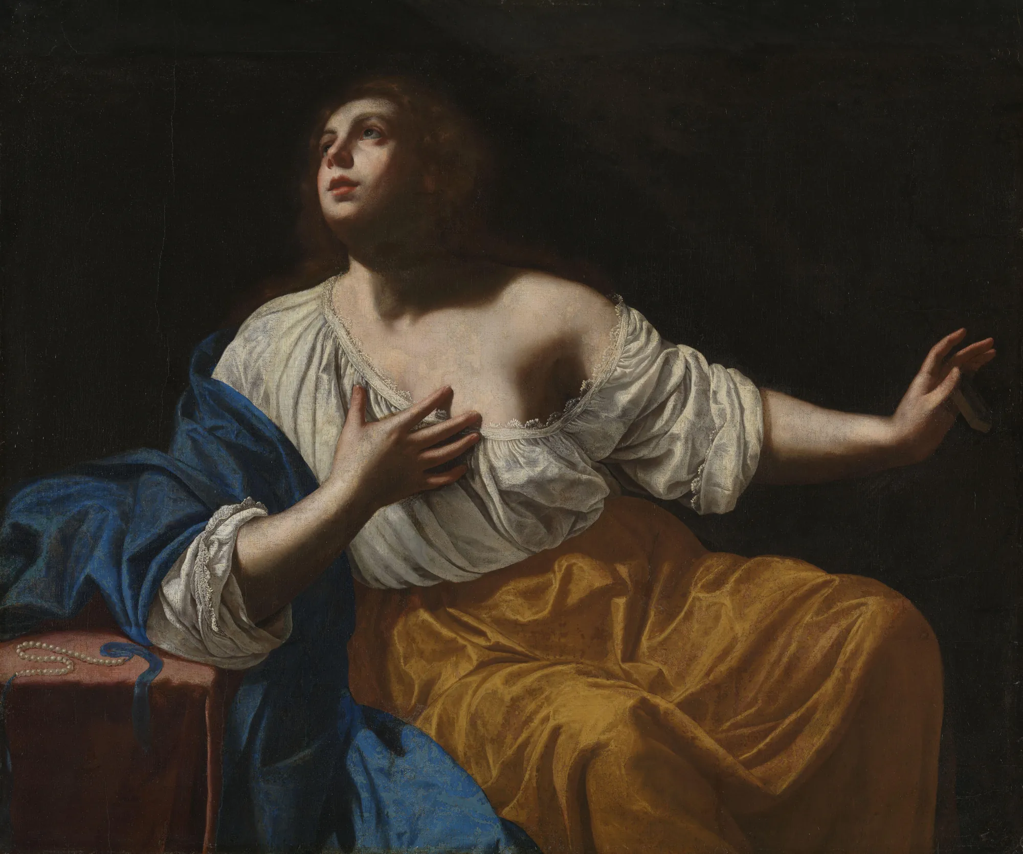 Mary Magdalene Penitent Mary Magdalene Penitent by Artemisia Gentileschi. A seated woman in vibrant yellow and blue garments gazes heavenward with an emotional expression against a deep black background.
