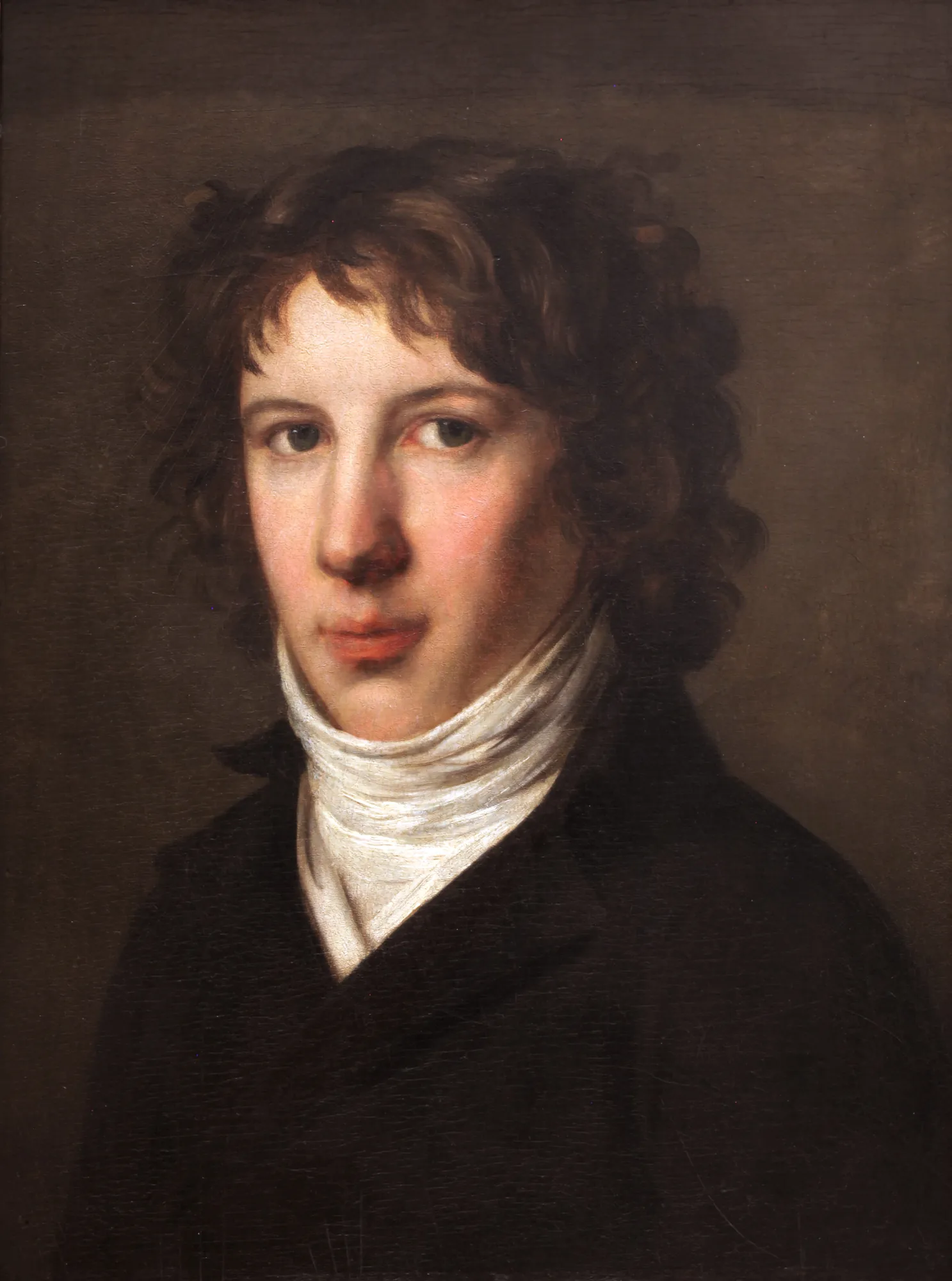 Louis Antoine de Saint-Just Louis Antoine de Saint-Just by Pierre-Paul Prud'hon. A portrait of a young man with dark curly hair and a voluminous white cravat, looking directly at the viewer against a dark background.