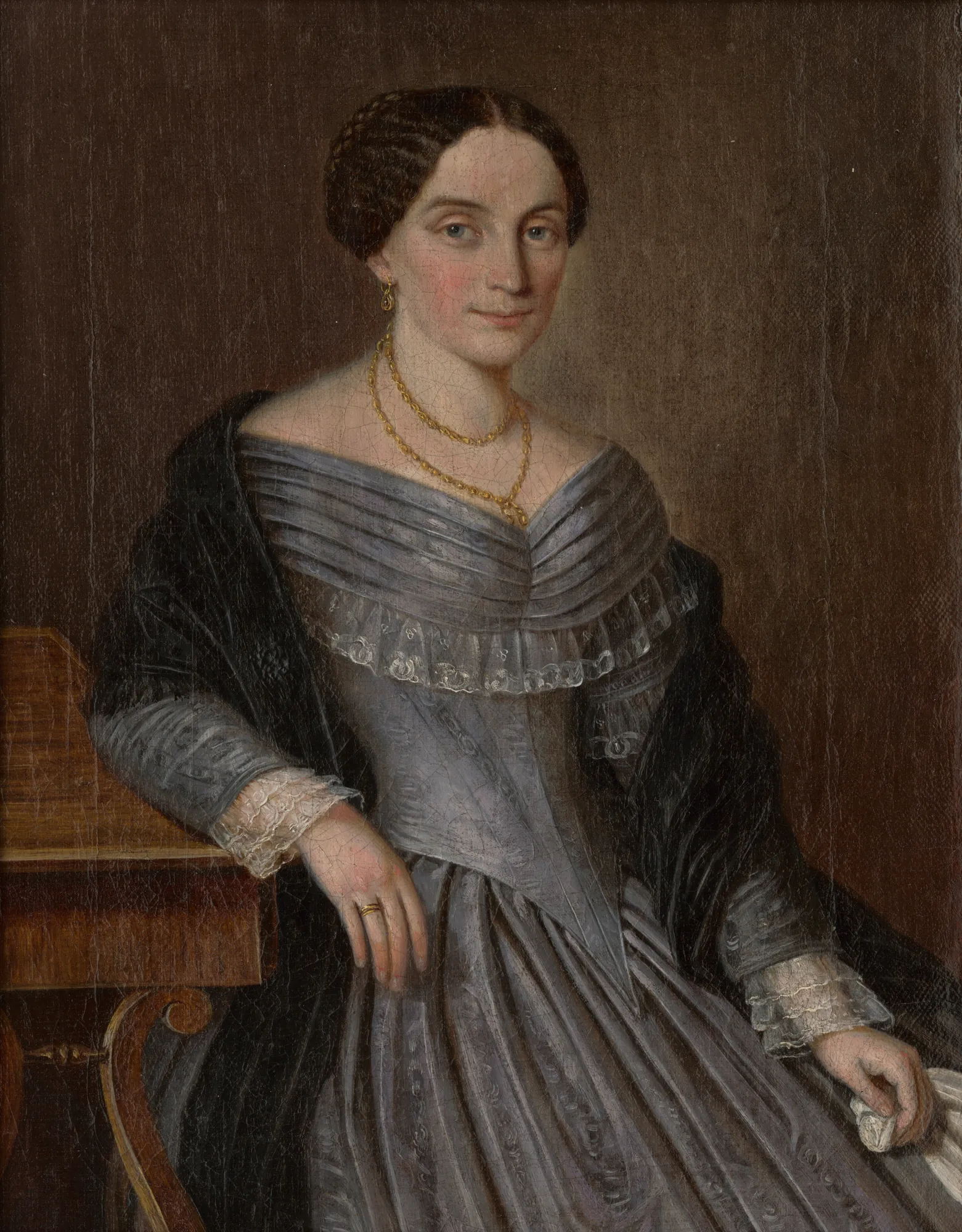 Portrait of Anna Makovická Portrait of Anna Makovická by Peter Michal Bohúň. A three-quarter length portrait of a woman with braided hair wearing a grey ruffled gown and a black shawl, seated next to a wooden table.