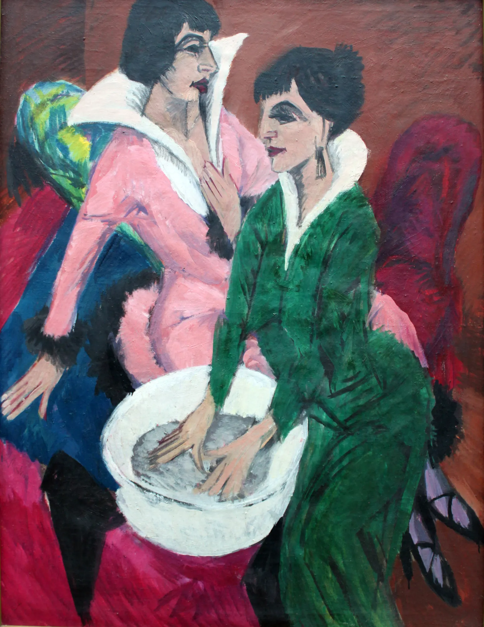 Two Women with a Washbasin (The Sisters) Two Women with a Washbasin (The Sisters) by Ernst Ludwig Kirchner. Two women with stylized, angular features, one in pink and one in green, are depicted standing near a white washbasin.