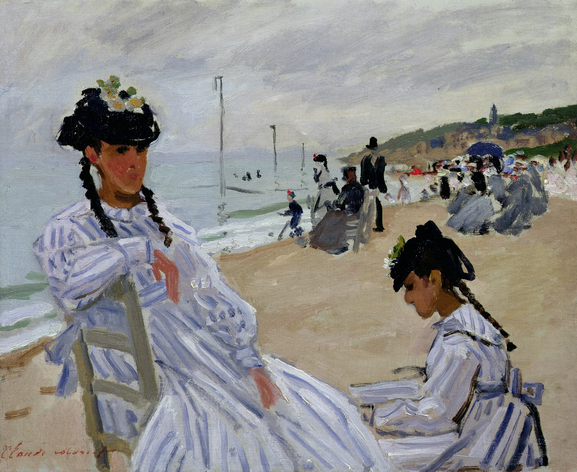 The Beach at Trouville The Beach at Trouville by Claude Monet. Two women in blue and white striped dresses sit on a sandy beach under an overcast sky, with other figures and a coastal hillside in the distance.