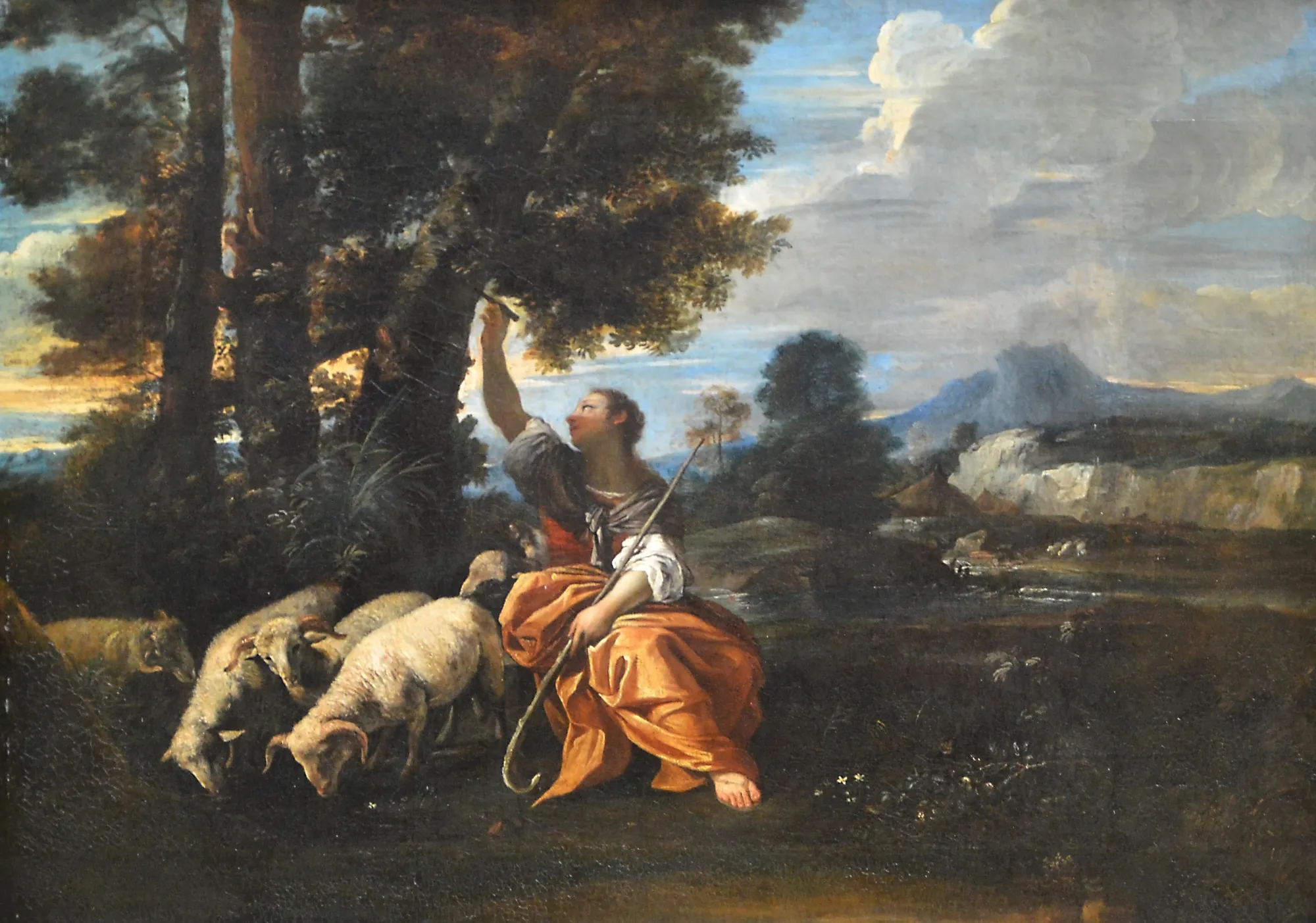 Erminia Carving Tancred's Name on a Tree Erminia Carving Tancred's Name on a Tree by Pier Francesco Mola. A woman in classical robes sits beside her flock of sheep while carving letters into the trunk of a large tree in a vast landscape.