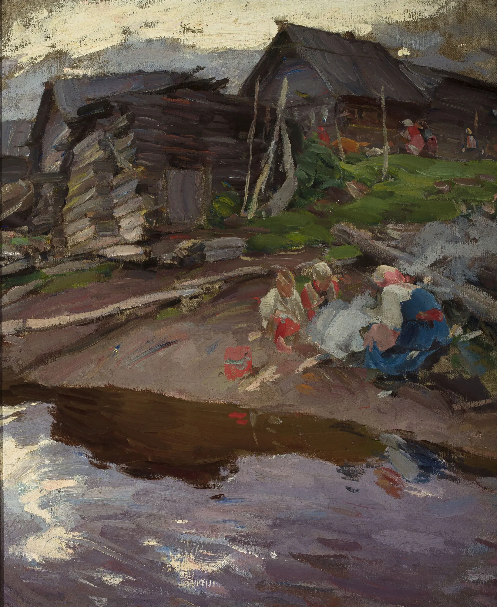 In the Evening In the Evening by Abram Arkhipov. A group of figures in traditional dress sits by the water near rustic log cabins under a dim evening sky.