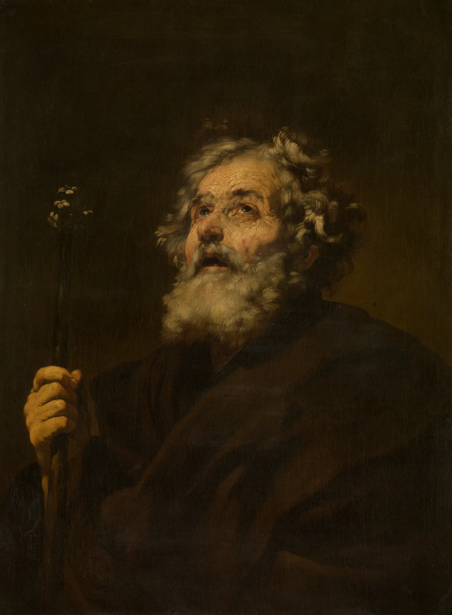 Saint Joseph Saint Joseph by Jusepe de Ribera. A dramatic chiaroscuro portrait of an elderly, bearded man looking upwards while holding a flowering staff.
