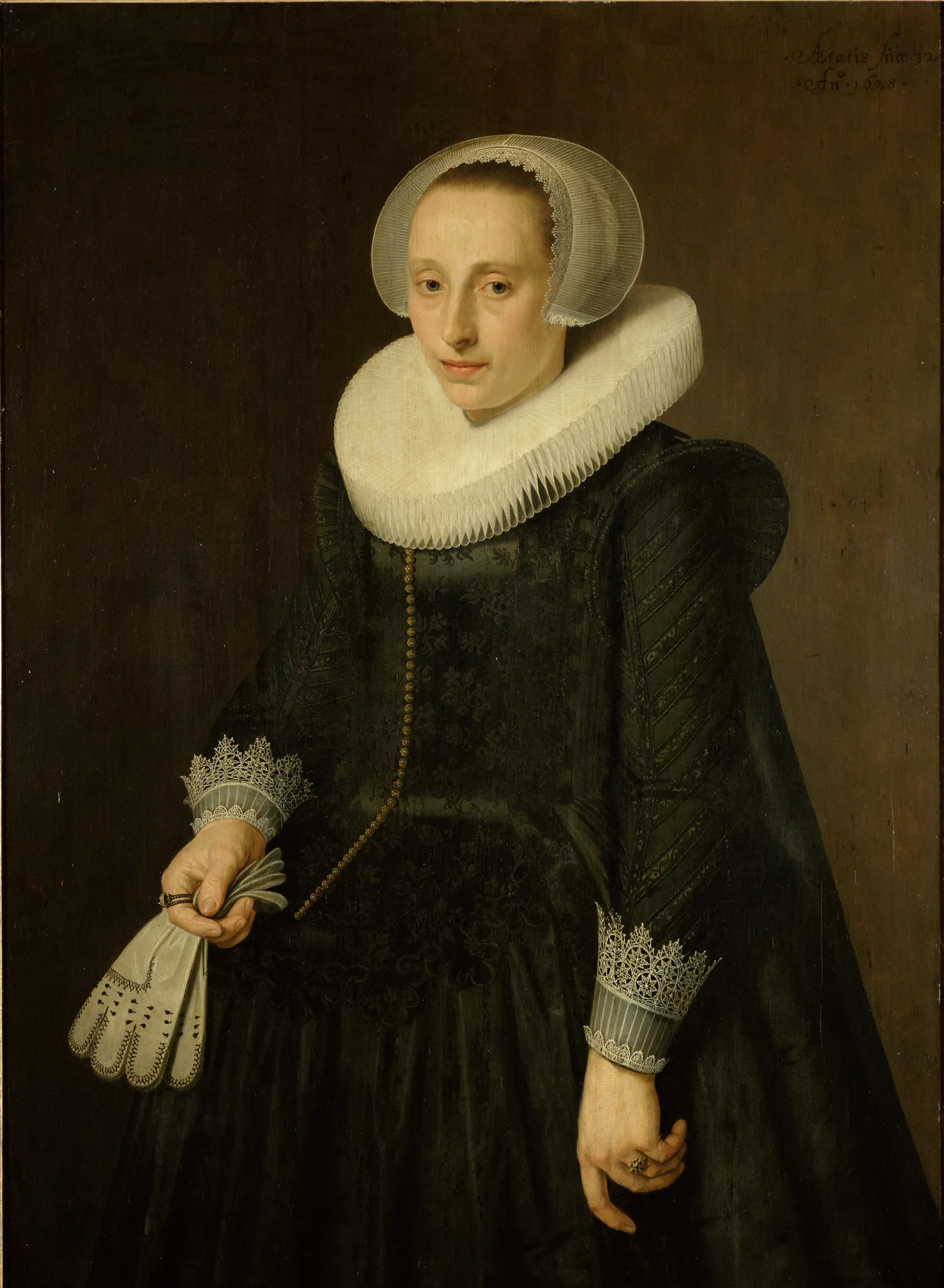 Portrait of a Woman Portrait of a Woman by Nicolaes Eliaszoon Pickenoy. A three-quarter length portrait of a woman in 17th-century Dutch attire, wearing a prominent white ruff and holding leather gloves.