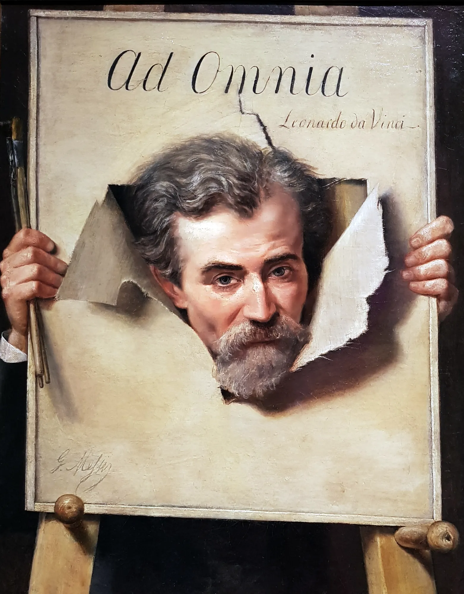 Portrait of a Man (Ad Omnia) Portrait of a Man (Ad Omnia) by Georges Méliès. A trompe-l'œil oil painting depicting a bearded man's head emerging through a torn canvas titled 'Ad Omnia', held by hands and resting on an easel.