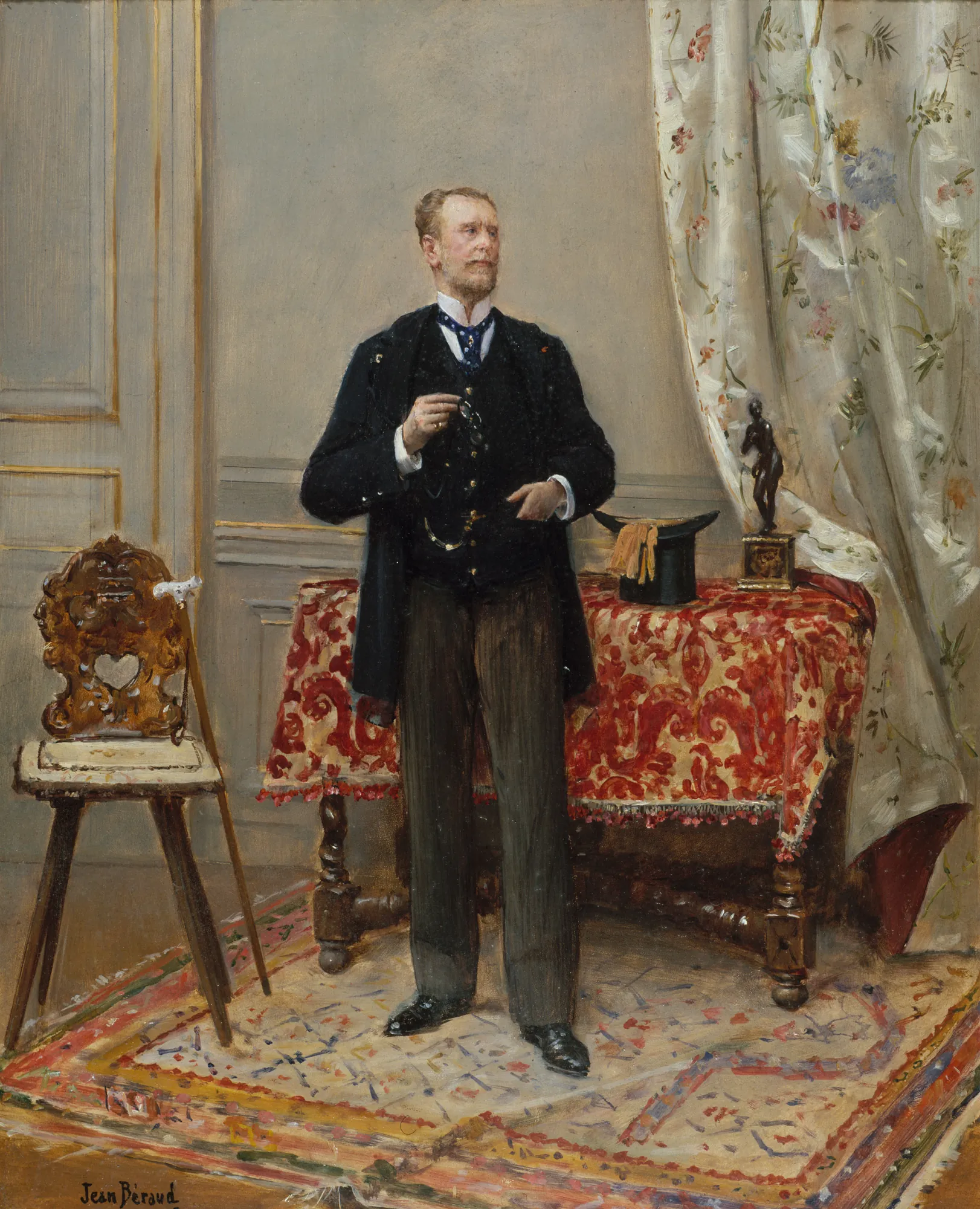 Edmond Taigny Edmond Taigny by Jean Béraud. A full-length portrait of a dapper man in a dark suit standing in a refined interior with a patterned rug and floral curtains.