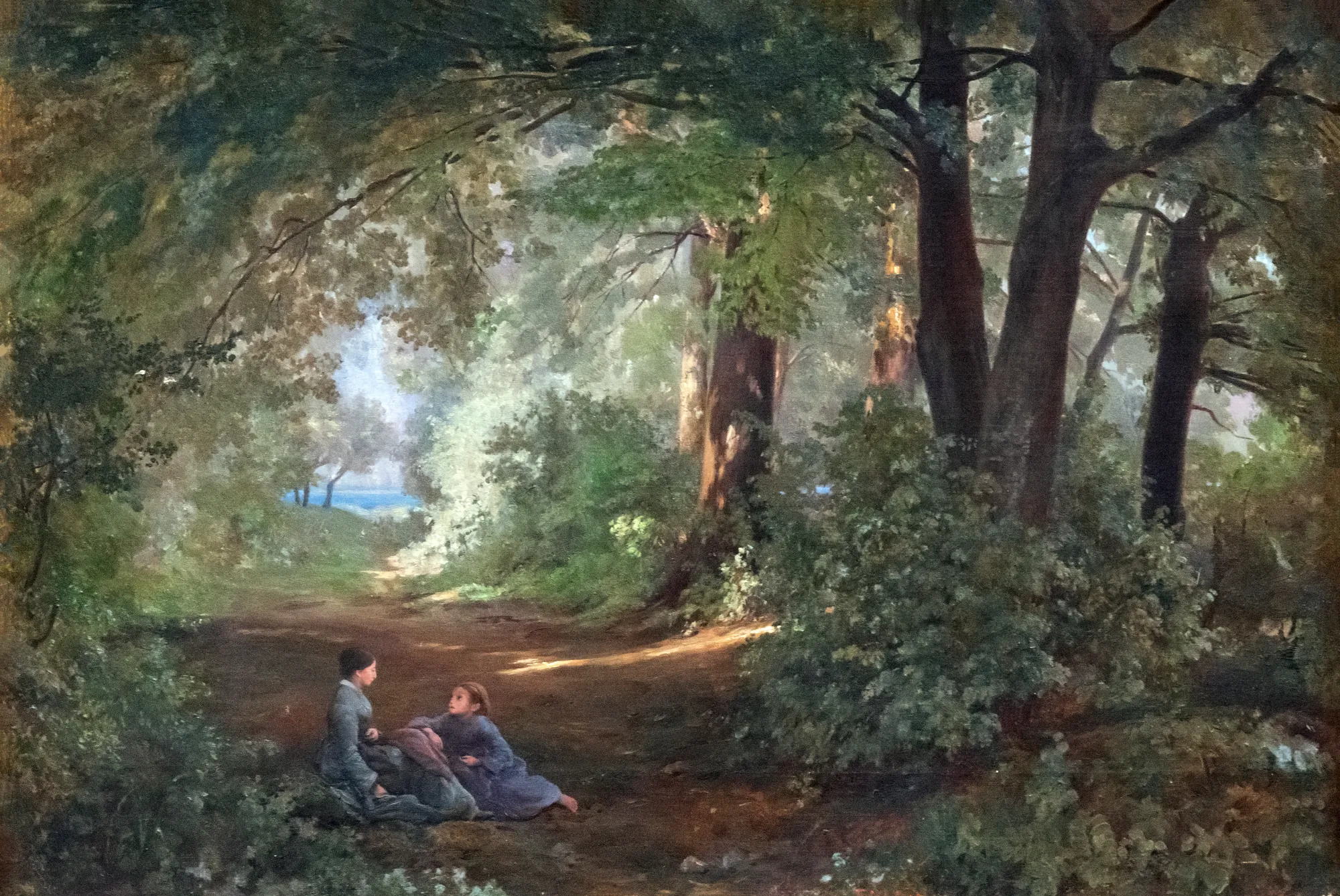 Conversation dans une allée près du lac Conversation dans une allée près du lac by Firmin Salabert. Two figures sit in conversation on a shaded woodland path leading toward a glimpse of water under a canopy of dense, sun-dappled trees.