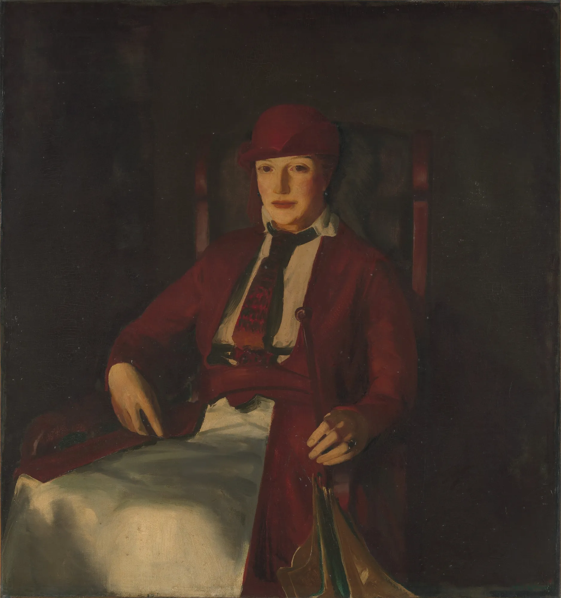 Mrs. Chester Dale Mrs. Chester Dale by George Bellows. A woman sits in a chair wearing a vibrant red hat and matching jacket over a white blouse and dark tie against a dark background.