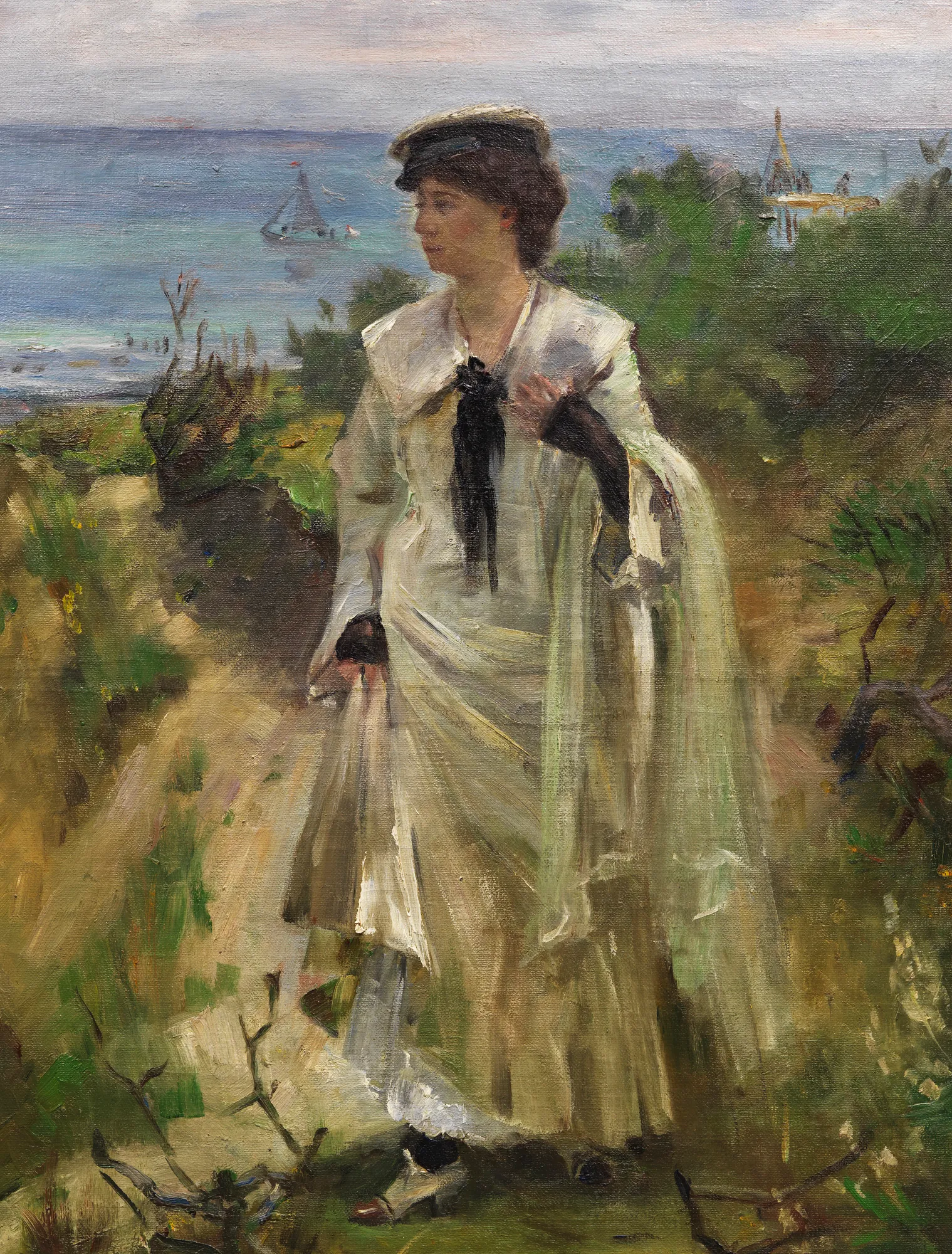 Am Ostseestrand Am Ostseestrand by Lovis Corinth. A woman in an elegant white dress and hat stands on a grassy dune overlooking a calm sea with a sailboat in the distance.