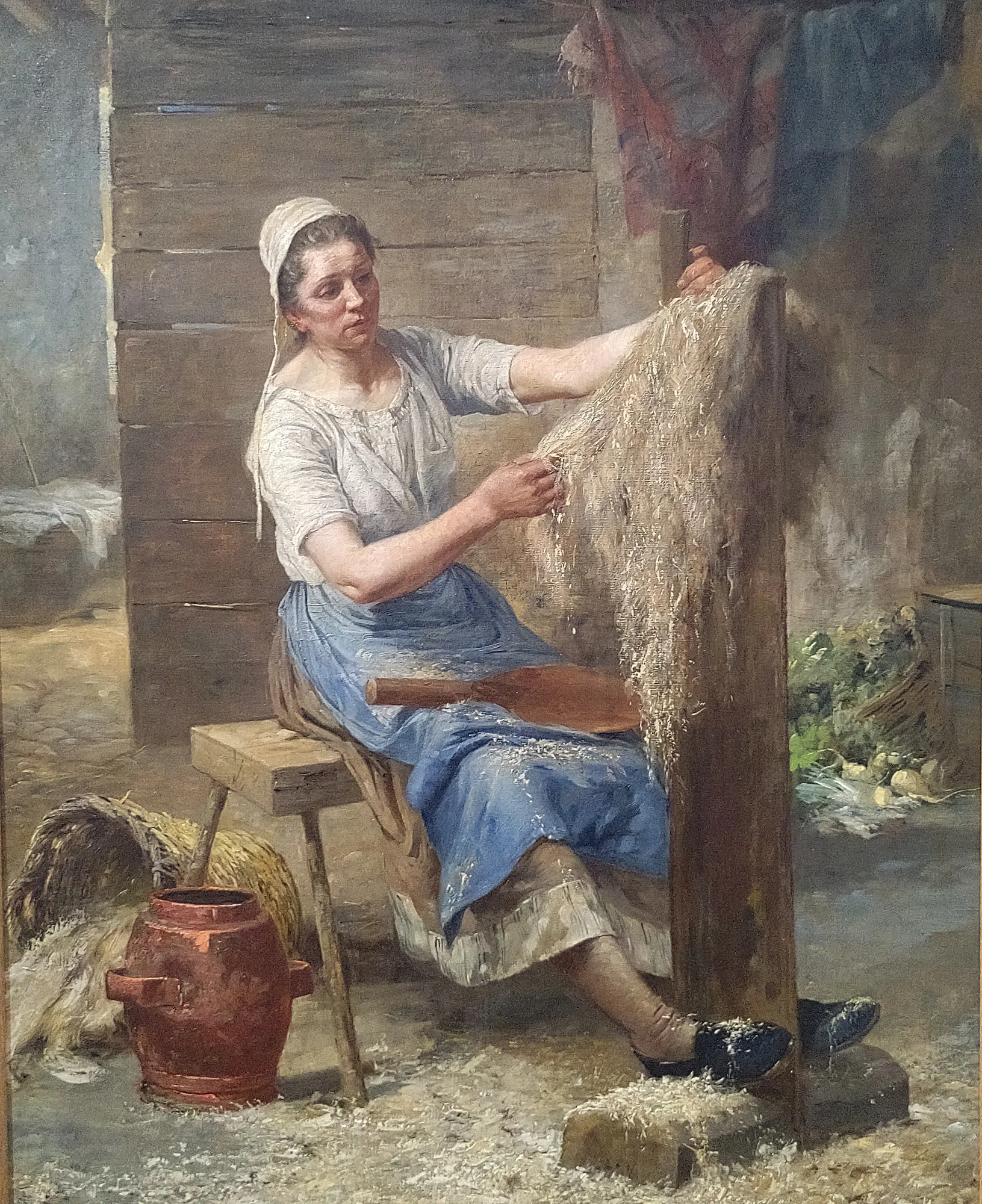 La Teilleuse de Chanvre La Teilleuse de Chanvre by Eugène Damas. A woman in a blue apron and white headscarf works with raw hemp fibers in a rustic interior.