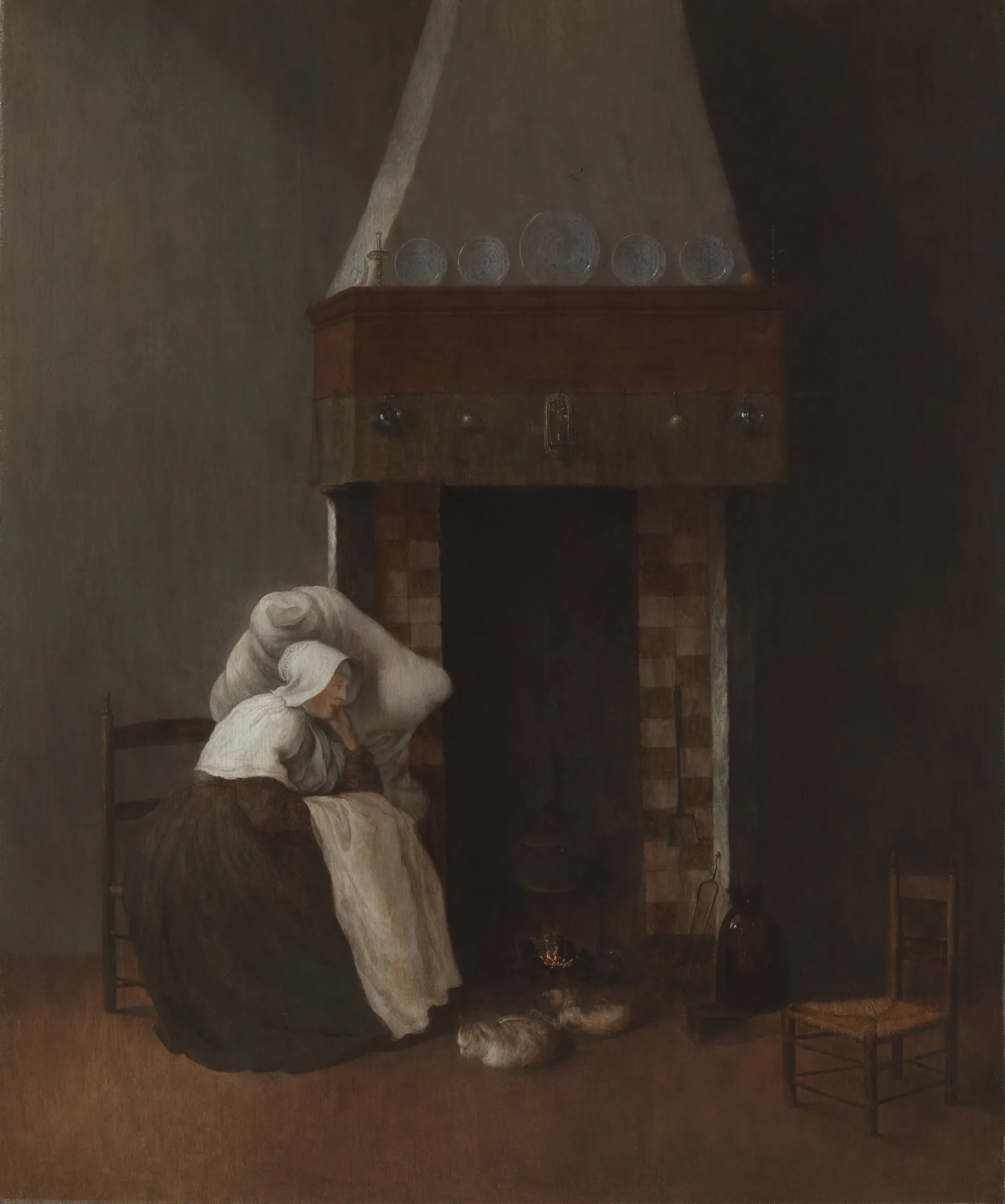 Interior with a Sick Woman by a Fireplace Interior with a Sick Woman by a Fireplace by Jacob Vrel. A woman wearing a white cap and dark dress sits leaning on a pillow by a large, tall fireplace in a dim, sparse interior.