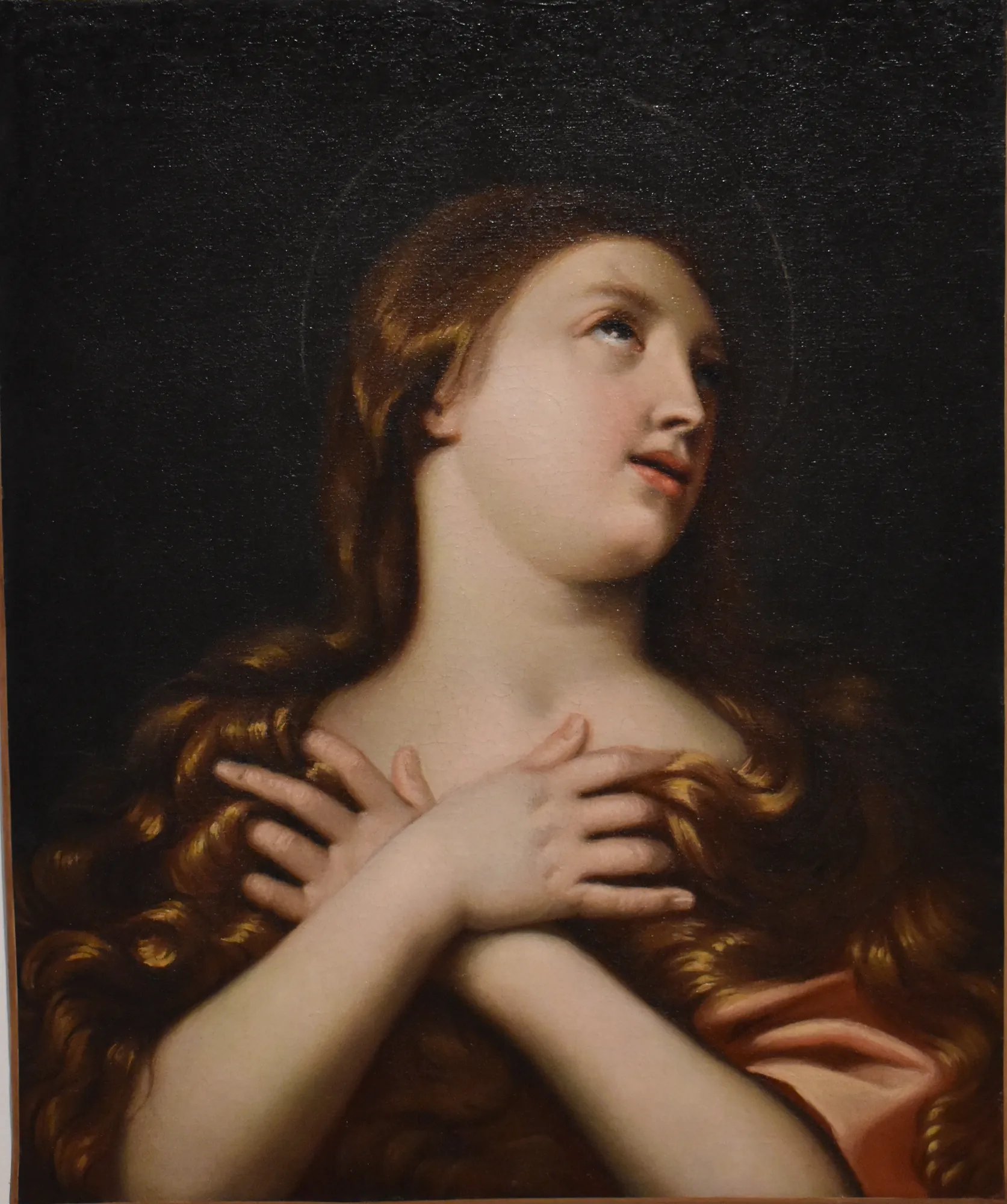 Sainte Marie Madeleine Sainte Marie Madeleine by Unknown Artist. A classical Baroque-style oil portrait of a woman with cascading auburn hair looking upward with her hands crossed over her chest against a dark background.